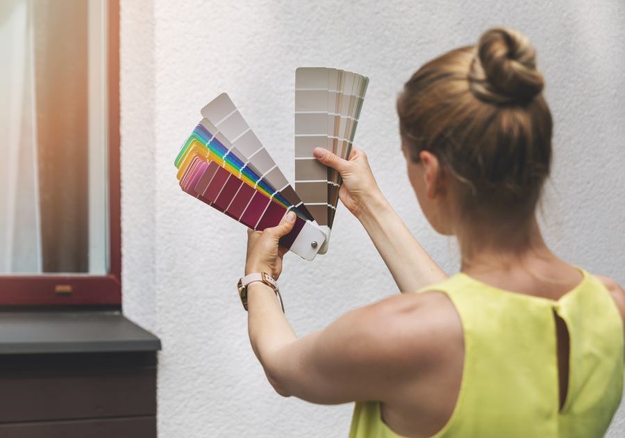 Choosing a paint colour from a fan deck against a wall