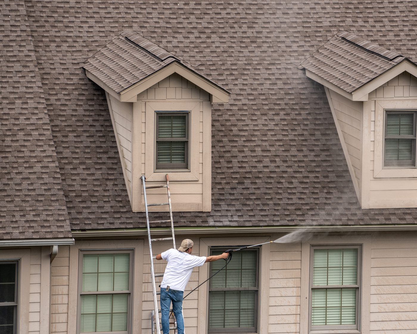 Painter on a ladder working on the exterior of a Miami home
