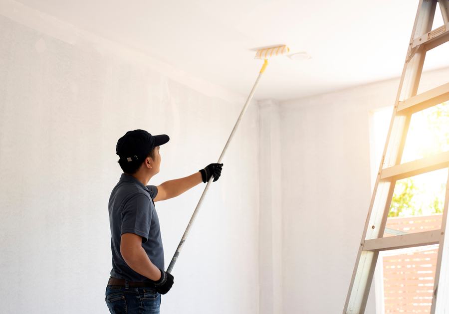 Painter rolling a freshly primed interior wall